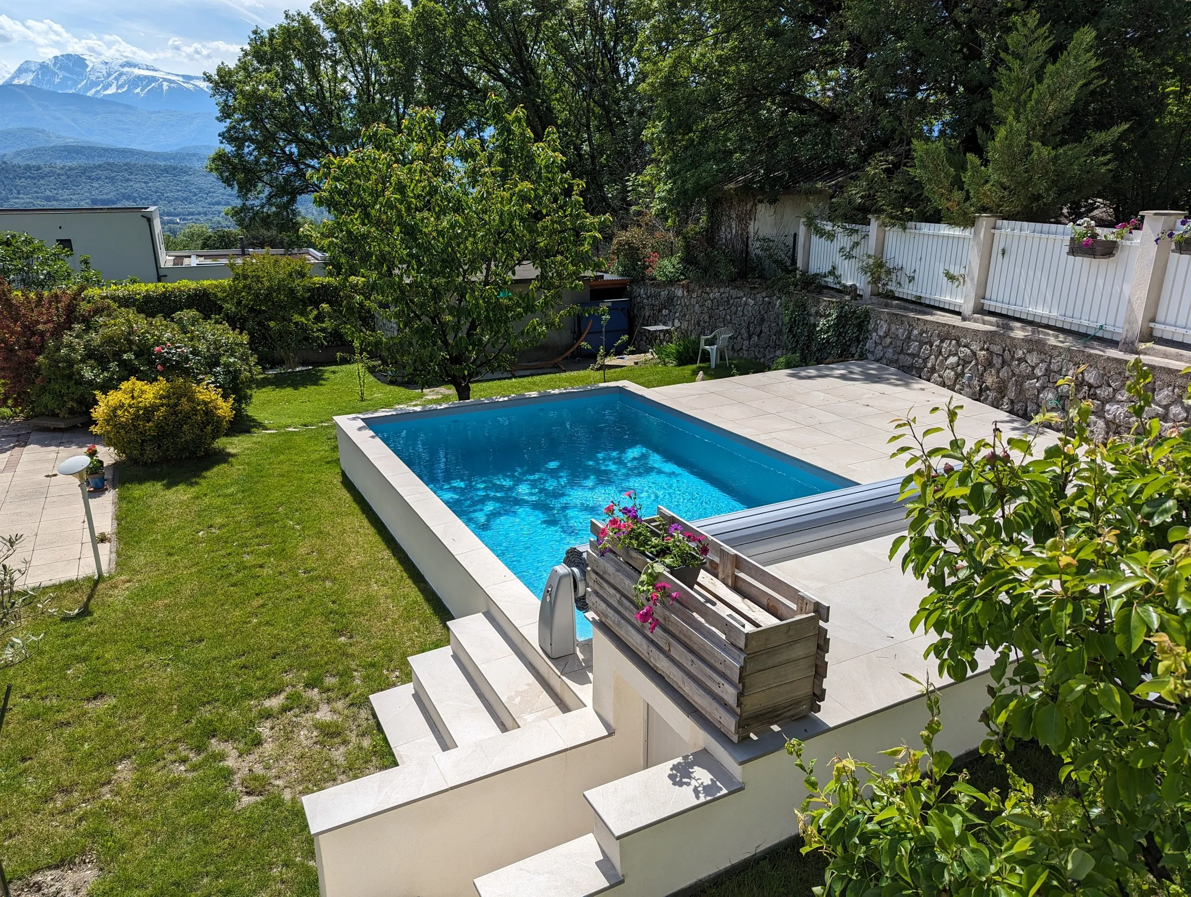 Piscine avec escalier dans un jardin face aux montagnes