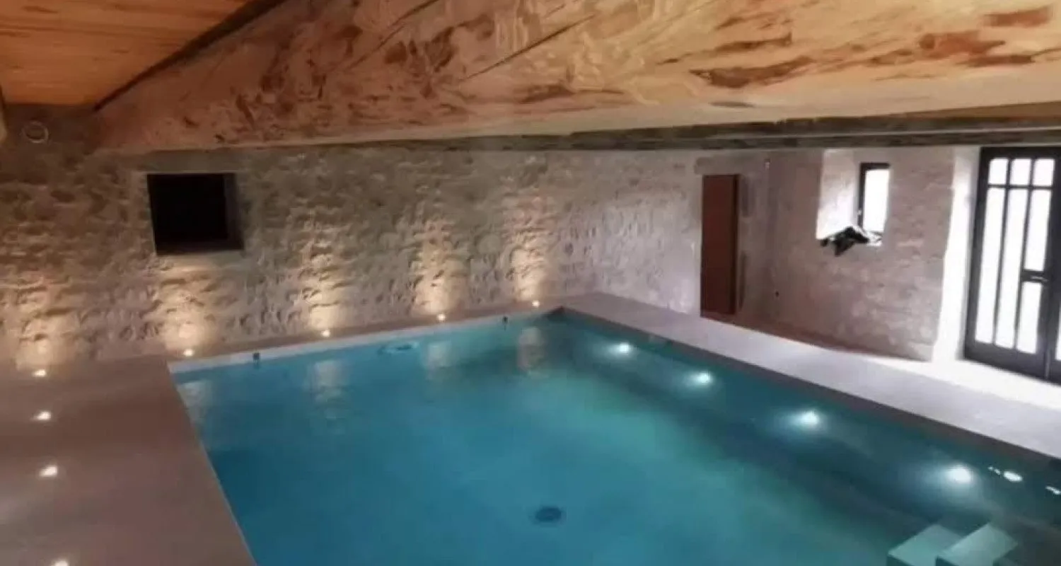Piscine intérieure éclairée dans une pièce en pierre