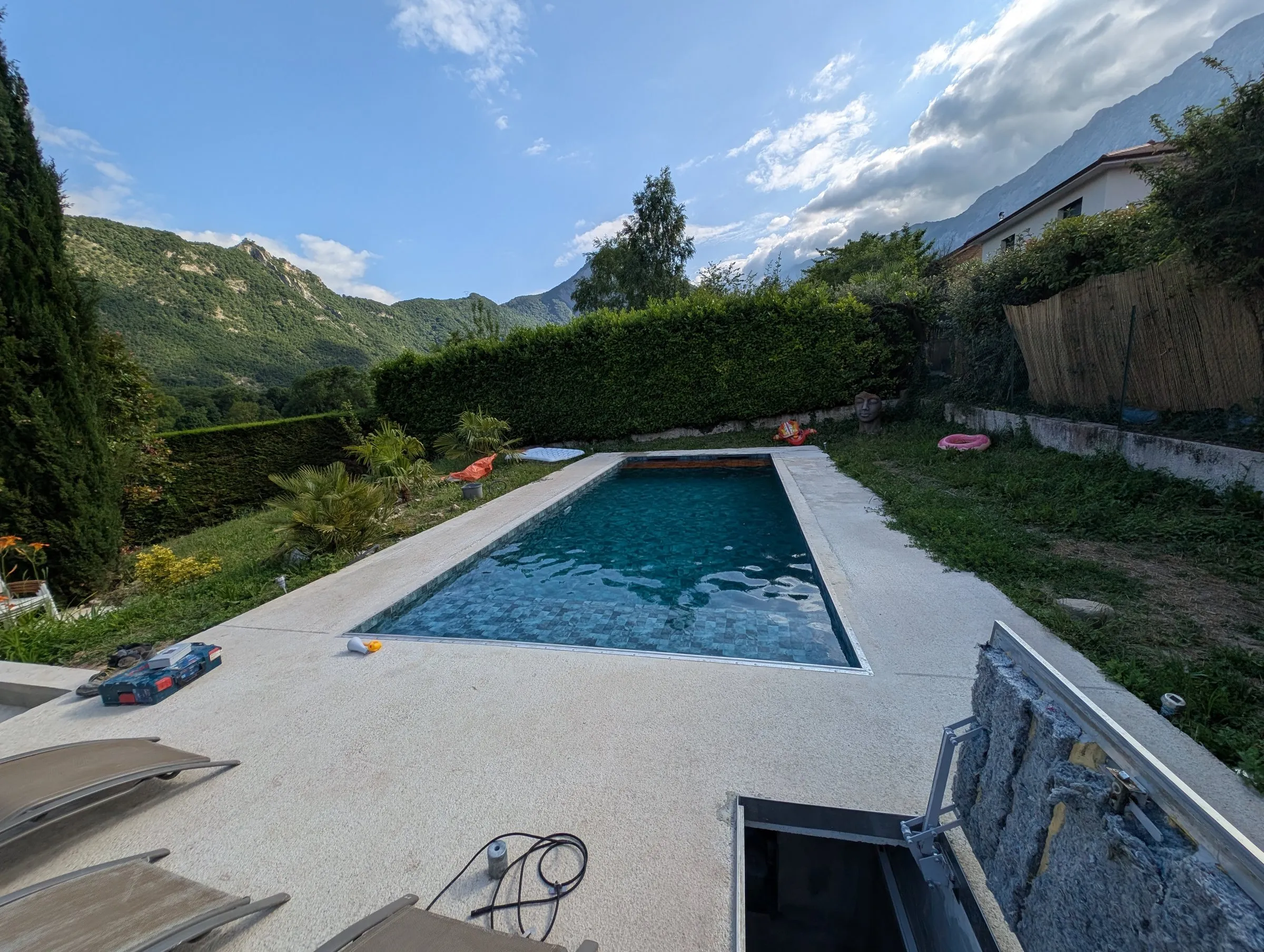 Piscine rénovée avec liner gris et vue sur les montagnes