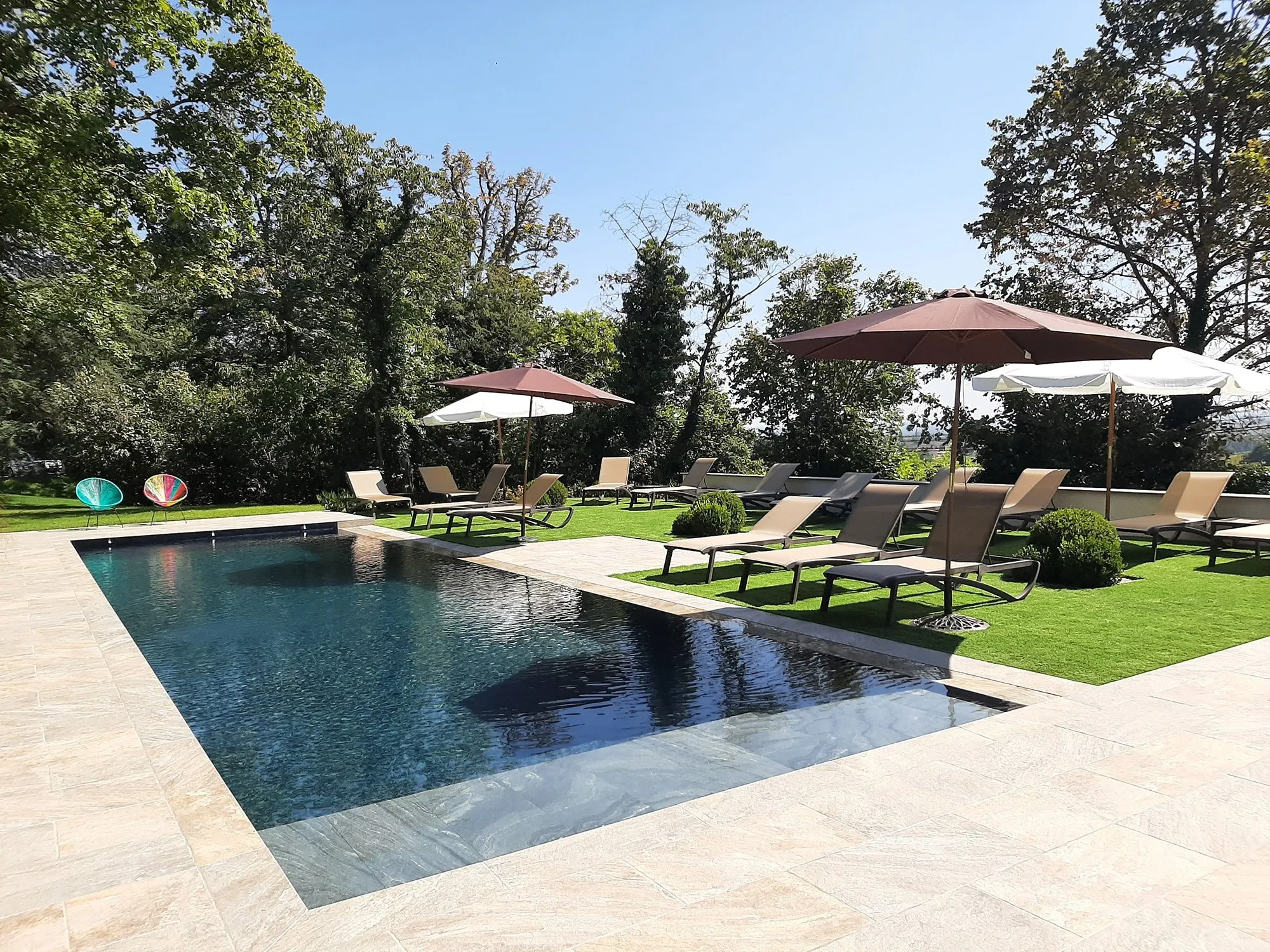 Piscine entretenue avec transats et parasols